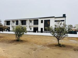 a white building with two trees in front of it at Carlo's Fairview Boutique - Hotel in Walvis Bay
