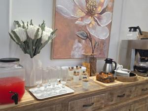 a wooden counter with glasses and a vase of flowers at Carlo's Fairview Boutique - Hotel in Walvis Bay