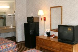 a hotel room with a tv and a mirror at Days Inn by Wyndham Nashville N Opryland/Grand Ole Opry in Nashville