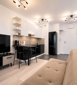 a living room with a couch and a kitchen at JBHotels Apartament DeLuxe przy Galaxy in Szczecin