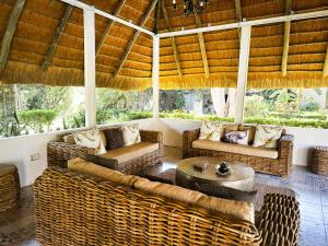 ein Wohnzimmer mit Korbmöbeln und einer Holzdecke in der Unterkunft Sunbirds Lodge Chobe in Kasane