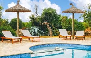 a pool with two chairs and two umbrellas at Sa Tanqueta De Calonge in Santanyi