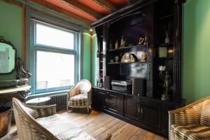 a living room with two chairs and a television at Royal Suites - Salon de Franz in Amsterdam