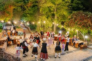 a group of people standing around in a park at night at Комплекс Сборяна in Gramatikovo +48 photos