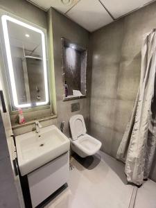 a bathroom with a sink and a toilet and a mirror at Supernova luxe heaven in New Delhi
