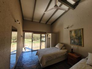 a bedroom with two beds and a window with a dog at Kunkura Game Lodge & Conference Centre in Modimolle +89 photos