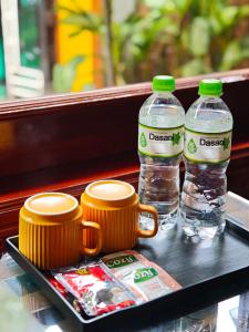 two bottles of water and two cups on a tray at L'Ananas Garden Homestay in Vũ Lâm