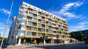 a tall building on a street with a blue sky at JBHotels Apartament DeLuxe przy Galaxy in Szczecin