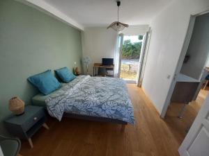 a bedroom with a bed and a couch and a window at Échappée iodée et nature à l'Île d'Oléron in Saint-Georges-dʼOléron +4 photos