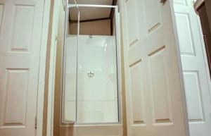a shower with a glass door in a bathroom at Karoo 62 Bush Motel in Ladismith +10 photos