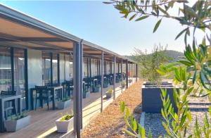 a building with tables and chairs on a deck at Karoo 62 Bush Motel in Ladismith