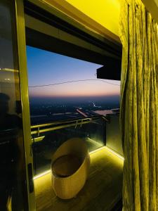 a room with a large window and a chair at Supernova luxe heaven in New Delhi