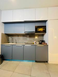 a kitchen with white cabinets and a sink at Supernova luxe heaven in New Delhi