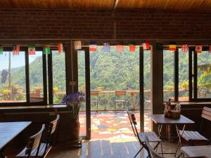 a room with tables and chairs and a view of a mountain at The Link farmstay in Sa Pả