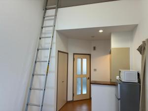 a ladder leaning up against a wall at apartment hotel myu in Mito