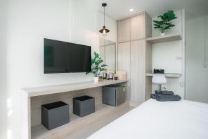 a bedroom with a flat screen tv on a wall at Sandana Studio Apartments - Studio 2 in Nathon Bay