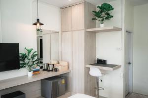 a living room with a tv and some plants at Sandana Studio Apartments - Studio 2 in Nathon Bay