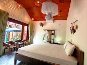 a bedroom with a bed and a table and a window at L'Ananas Garden Homestay in Vũ Lâm +32 photos