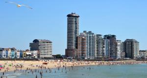 eine Gruppe von Menschen an einem Strand mit Gebäuden in der Unterkunft Hotel Restaurant Piccard in Vlissingen