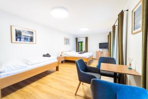 a bedroom with two beds and a table and chairs at Pivovar Prachatice, Horní 174 & Areál Knížecí dvůr U Stadionu 203 in Prachatice