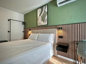 a bedroom with a white bed and a green wall at Akasa Rooms Estación in Alicante
