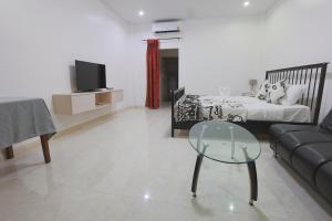 a living room with a couch and a glass table at Chalong Pool Courtyard in Ban Na Bon