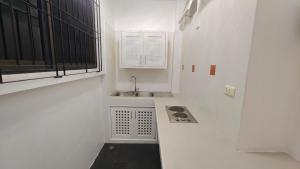 a small white kitchen with a sink and a window at Chalong Pool Courtyard in Ban Na Bon +13 photos
