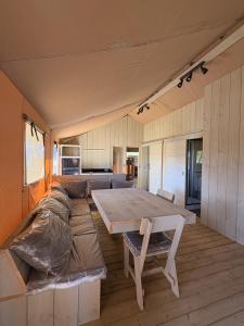 a large room with a table and a couch at Camping Derby Loredo by Mola! in Loredo