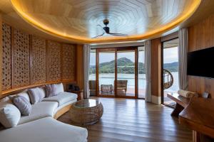 a living room with a couch and a tv at SINAE Phuket Luxury Hotel in Phuket +161 photos
