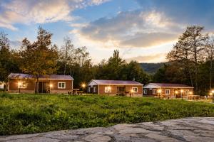 a group of lodges in a field at dusk at Комплекс Сборяна in Gramatikovo