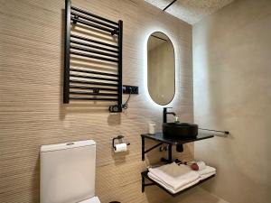 a bathroom with a toilet and a sink and a mirror at Akasa Rooms Estación in Alicante +18 photos