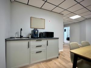 an office with a counter with a microwave and a table at Akasa Rooms Estación in Alicante
