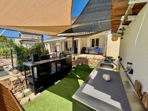 a backyard with a kitchen and a garden with grass at Les Carnoulettes in Carnoules