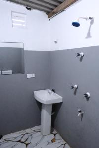 a bathroom with a white sink and a mirror at Wonder Surf Hostel in Arugam Bay