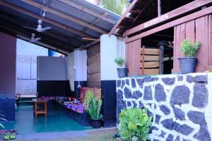 a patio with a wall and a table and a tv at Wonder Surf Hostel in Arugam Bay