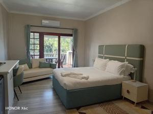 a bedroom with a large bed and a couch at Katberg Hotel & Mountain Resort in Karberg