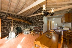 een woonkamer met een houten tafel en een keuken bij Casa do Alambique in Santa Luzia