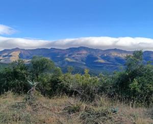 a view of a mountain range with clouds in the sky at Katberg Hotel & Mountain Resort in Karberg