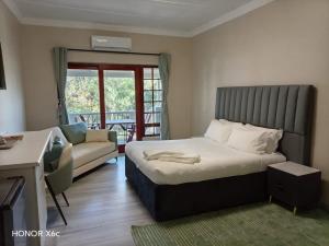 a hotel room with a bed and a couch at Katberg Hotel & Mountain Resort in Karberg