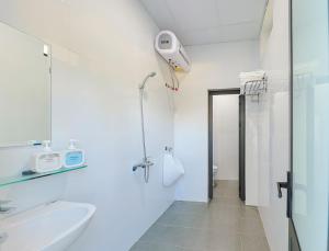 a white bathroom with a sink and a shower at 359 Beach Hotel in Phú Xá +37 photos