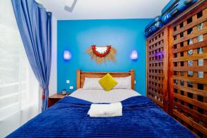 a blue bedroom with a bed with a blue wall at Zanzibar,Fumbatown Cozy 1 bed Apartment in Fumba +70 photos