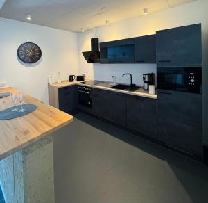a kitchen with a table and a clock on the wall at Hollender Hof in Bongard