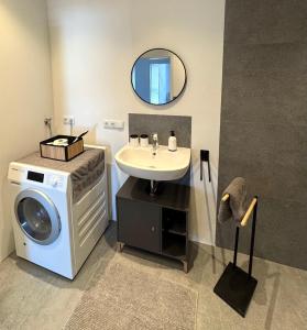 a bathroom with a sink and a washing machine at Hollender Hof in Bongard +49 photos
