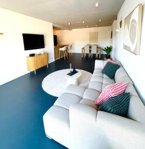 a living room with a white couch and a tv at Hollender Hof in Bongard