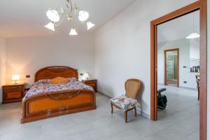 a bedroom with a bed and a chair and a mirror at Villa Caterina in Solarino