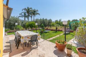 a table and chairs in a patio with a garden at Villa Caterina in Solarino