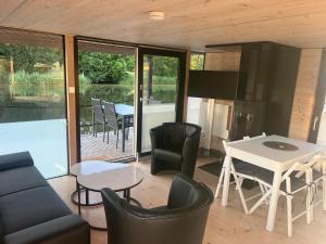 a living room with a table and chairs at Hausboot Resort Nordseeküste in Wilhelmshaven
