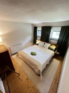a bedroom with a large white bed and two windows at Apartmány2 - Náhlov in Frymburk