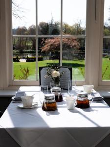 a table with a white table cloth with jars of honey at St Michael's Manor Hotel - St Albans in St. Albans