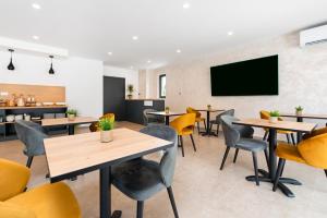 a restaurant with tables and chairs and a flat screen tv at Asterias Residence - New Opening 2026 in Rovinj